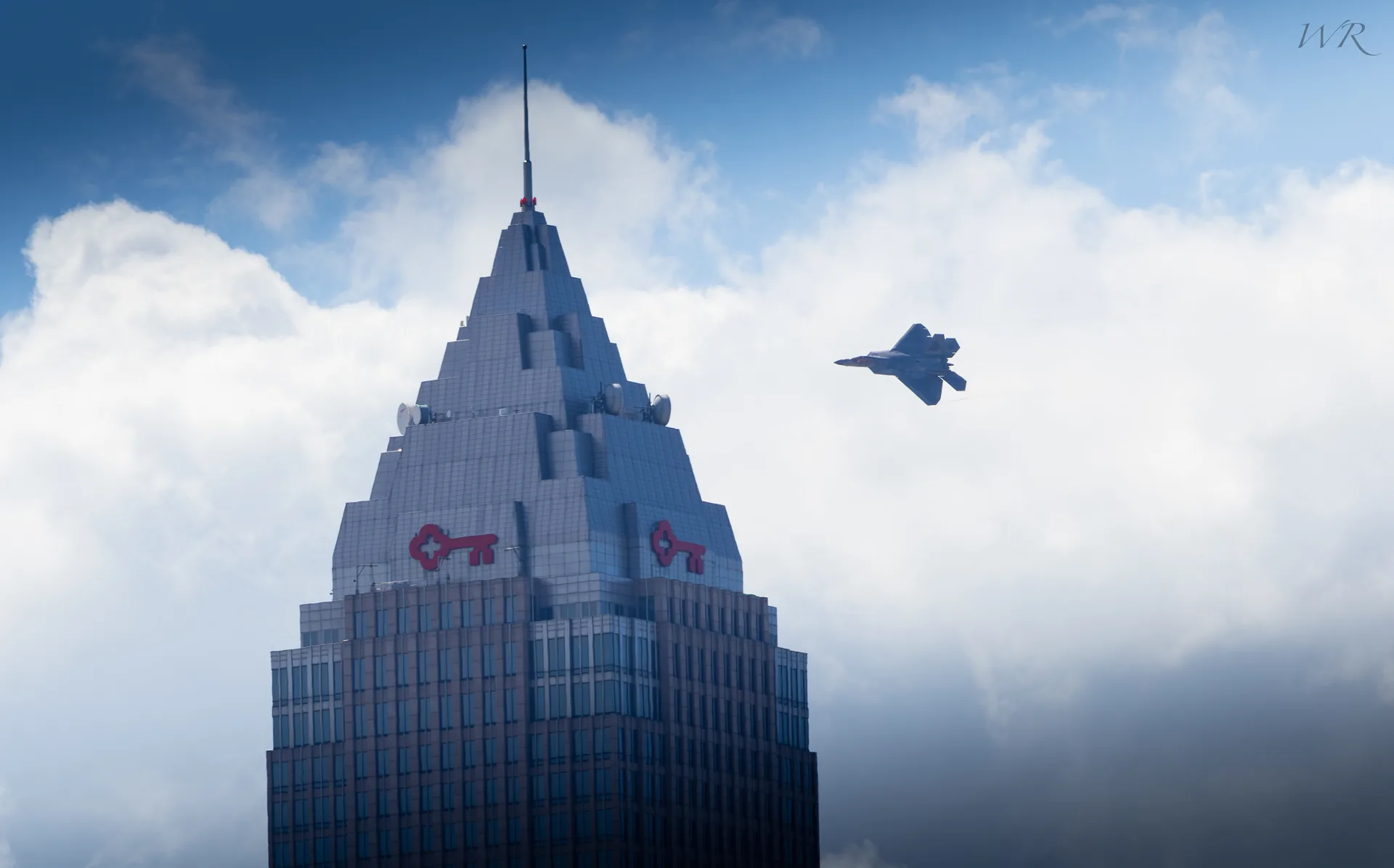 Fighter jet flying past a downtown Cleveland skyscraper