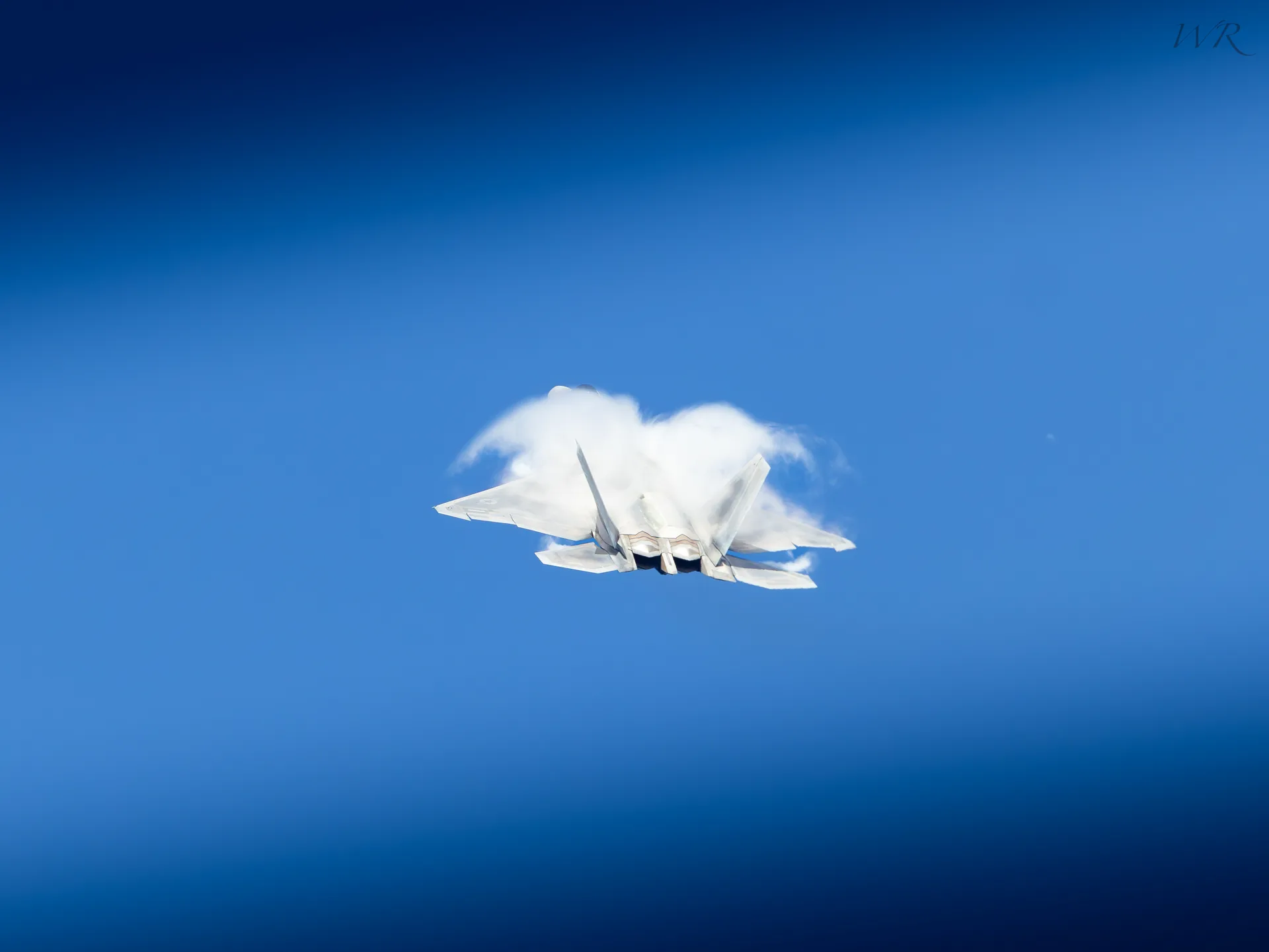 Fighter jet emerging through a cloud