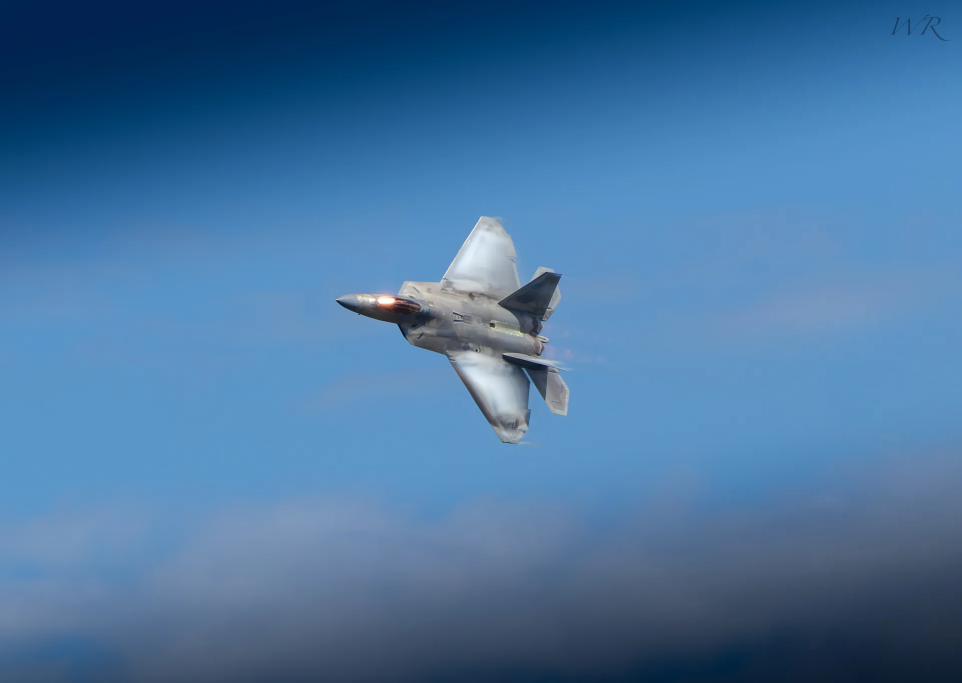 Fighter jet banking above the clouds
